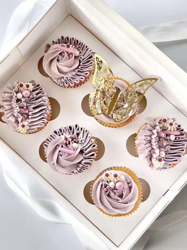 Lilla cupcakes med rysjer, perler og en gullfarget sommerfugl